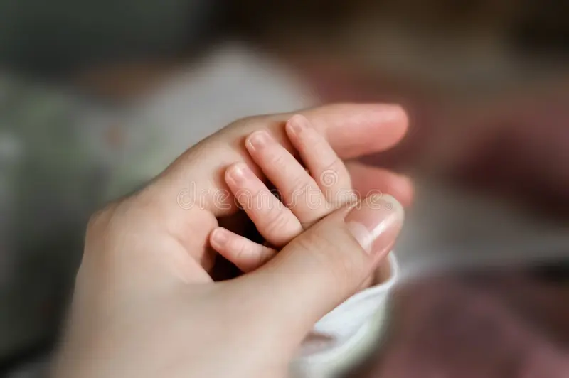 el-cierre-encima-de-la-mano-del-bebé-puso-en-mamá-oficio-enfermera-y-se-relajan-casa-interior-cuarto-niños-entrada-pecho-madre-141112814